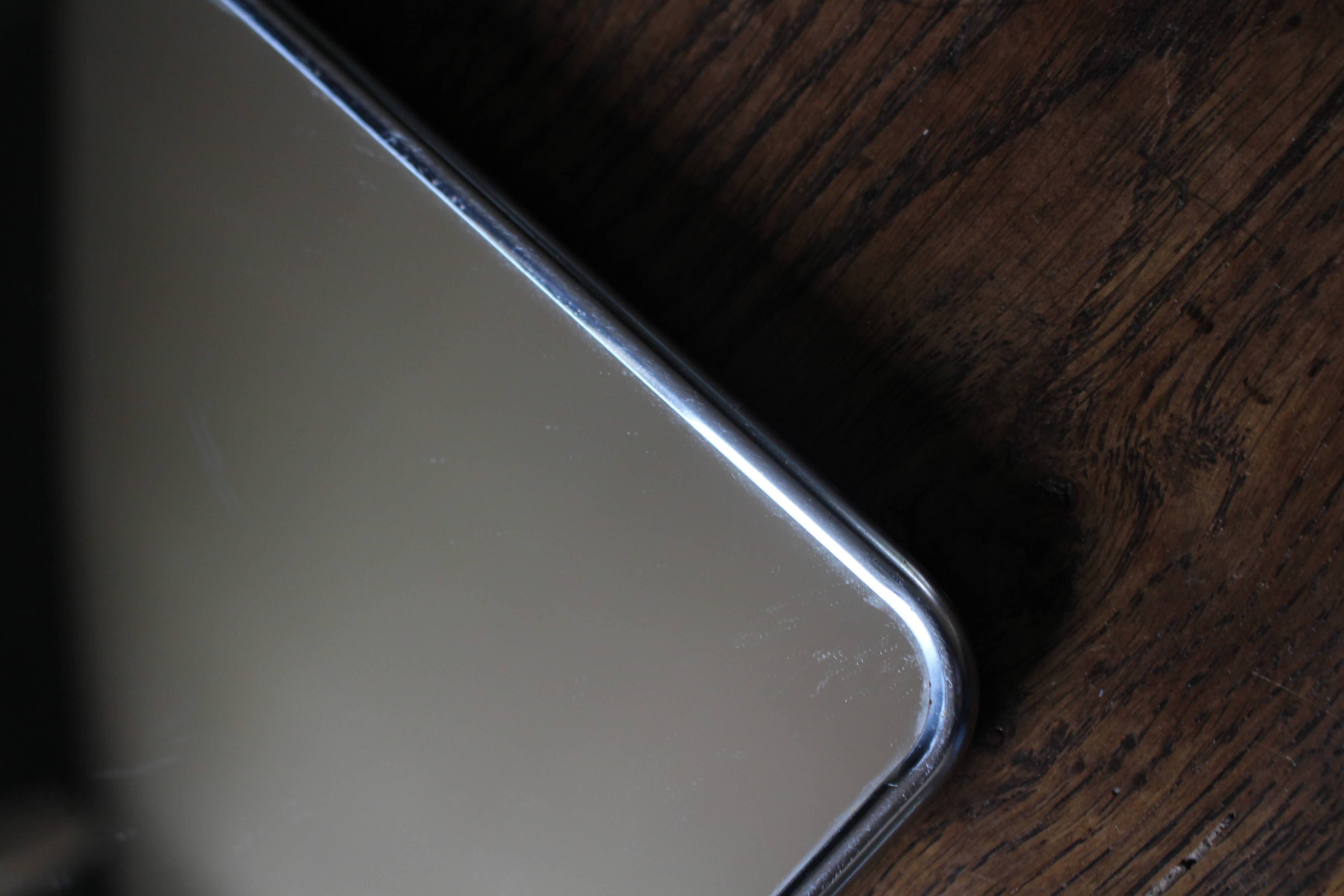 Simple rectangular barber mirror with a stand.