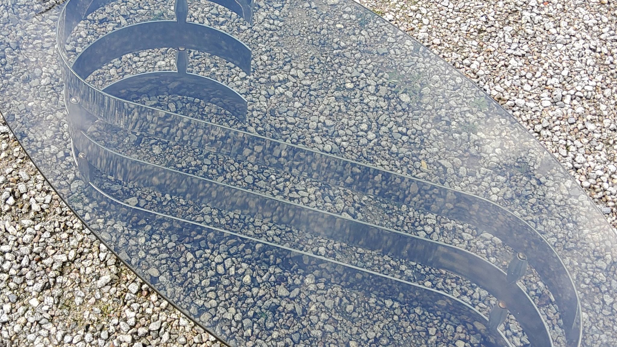 Oval coffee table of the 70s chromed metal base in s smoked glass top