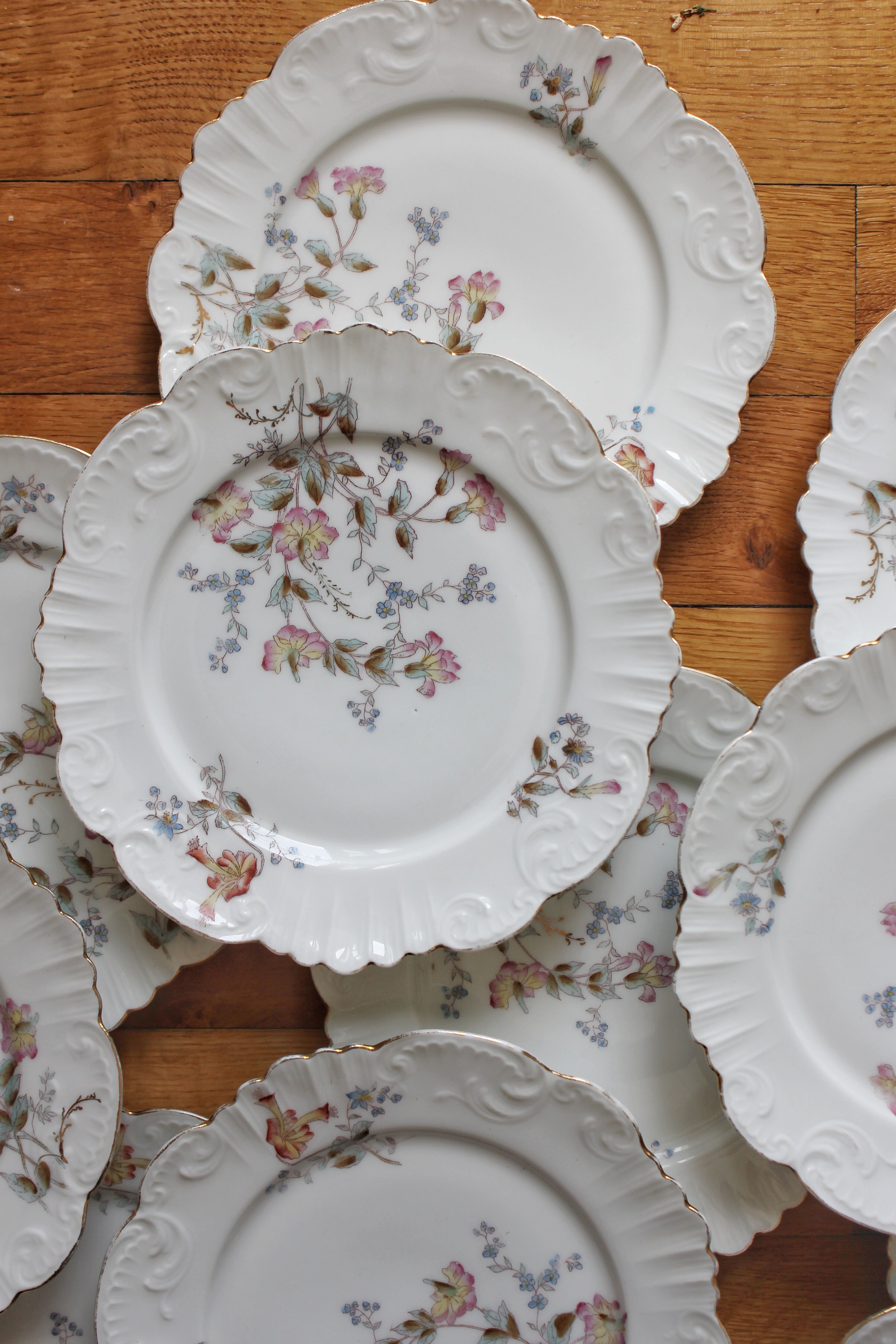 12 assiettes à dessert en porcelaine ancienne décor polychrome floral début XXe