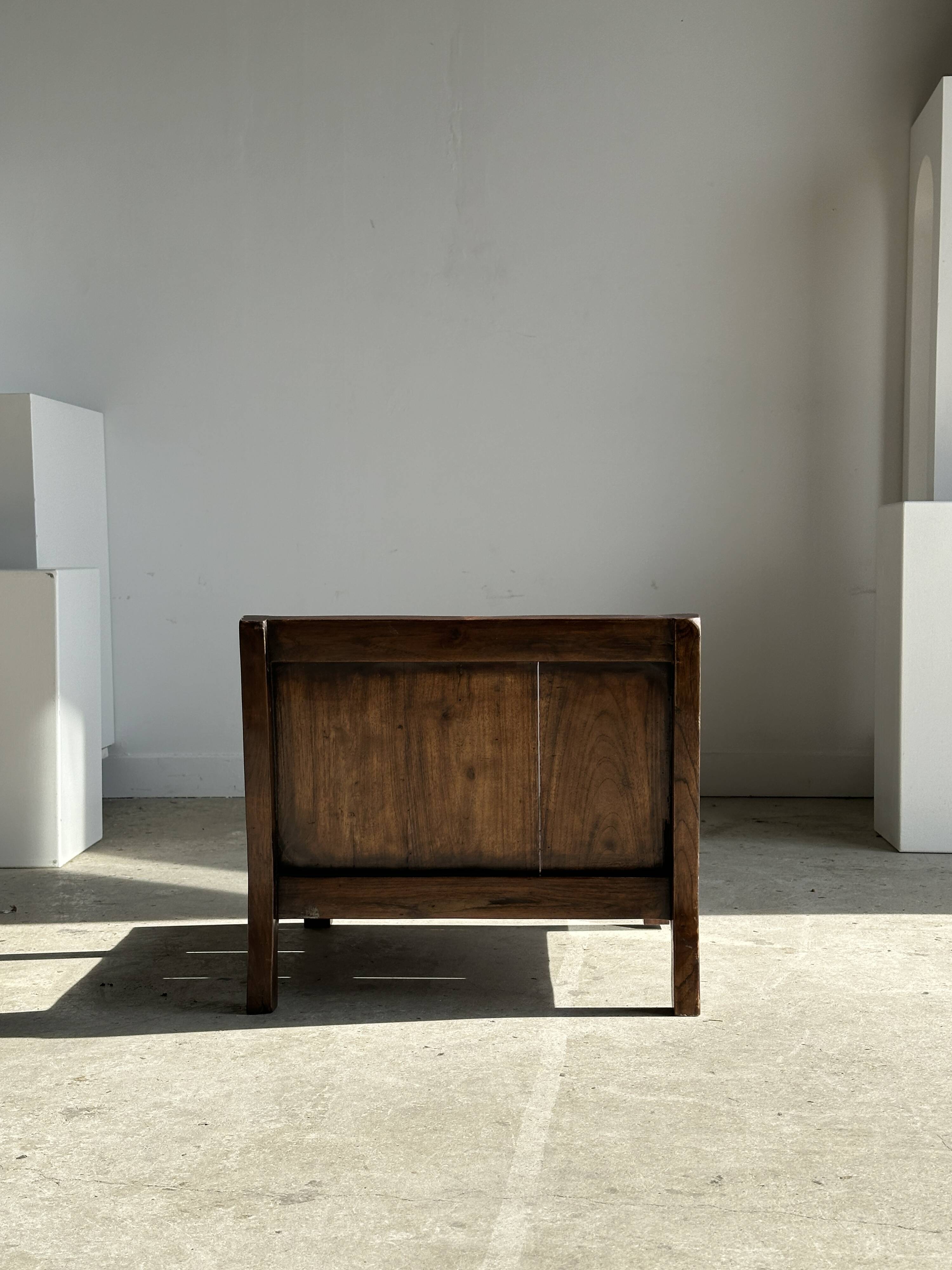 Small low armchair in varnished brown wood