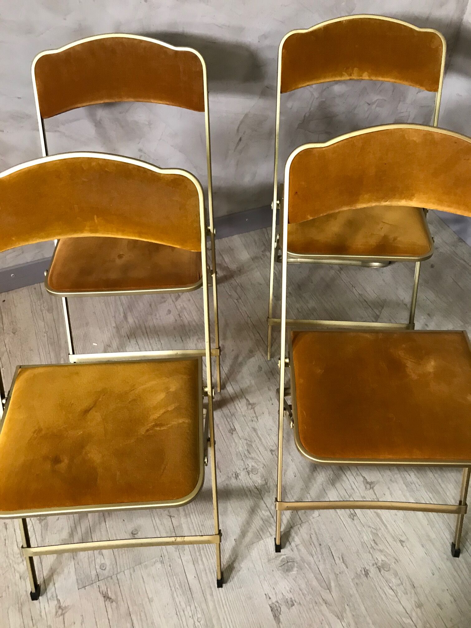 Four folding velvet and brass chairs