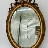 Antique oval gilded mirror with wooden frame and stucco detail