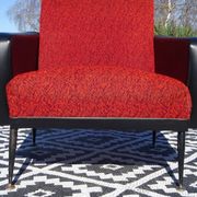 Pair of vintage armchairs in black faux leather and red fabric.