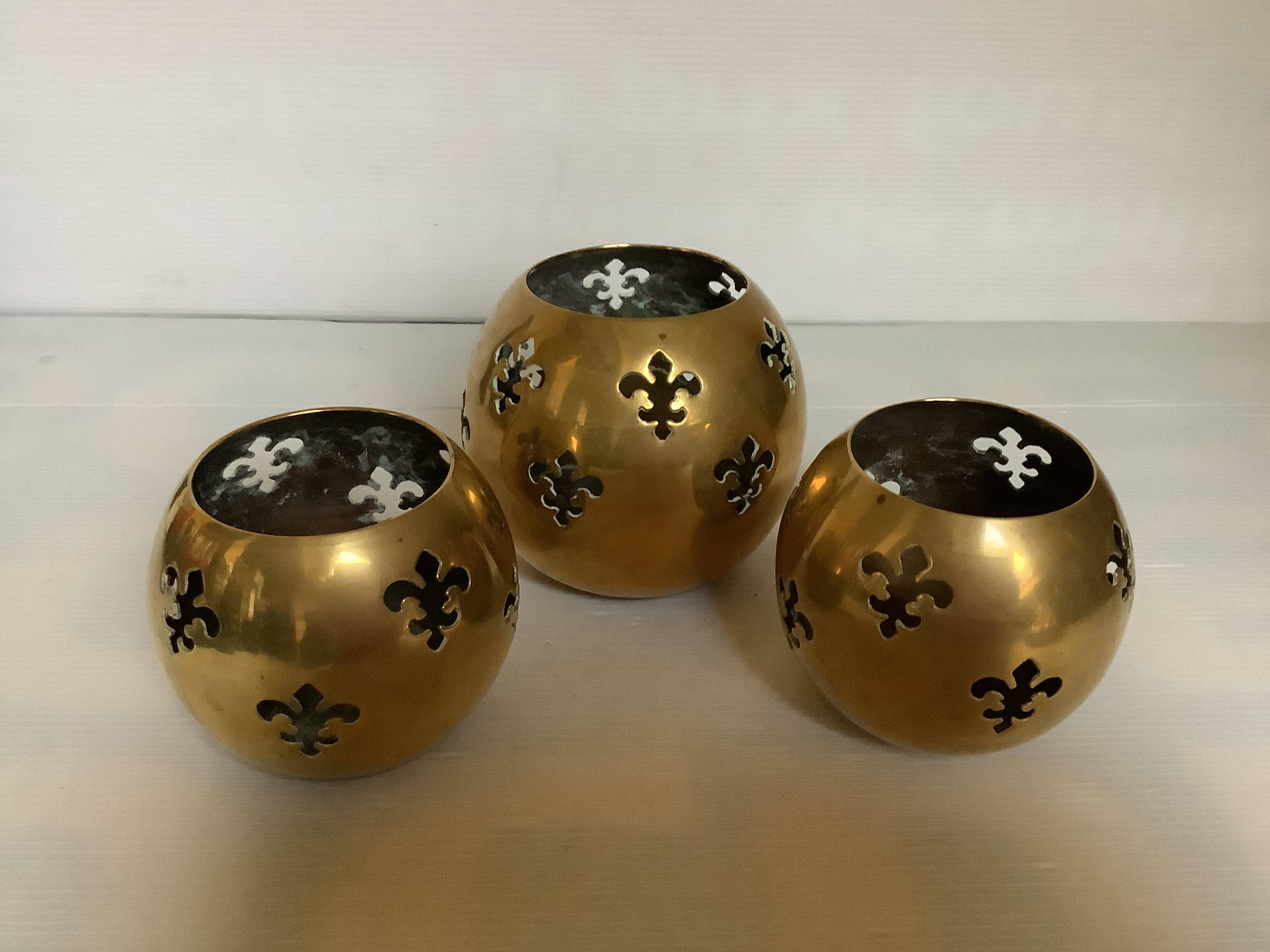 Trio of brass fleur-de-lis candle holders