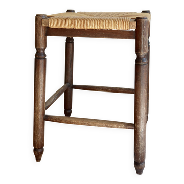 Antique square wooden stool with a woven straw seat.
