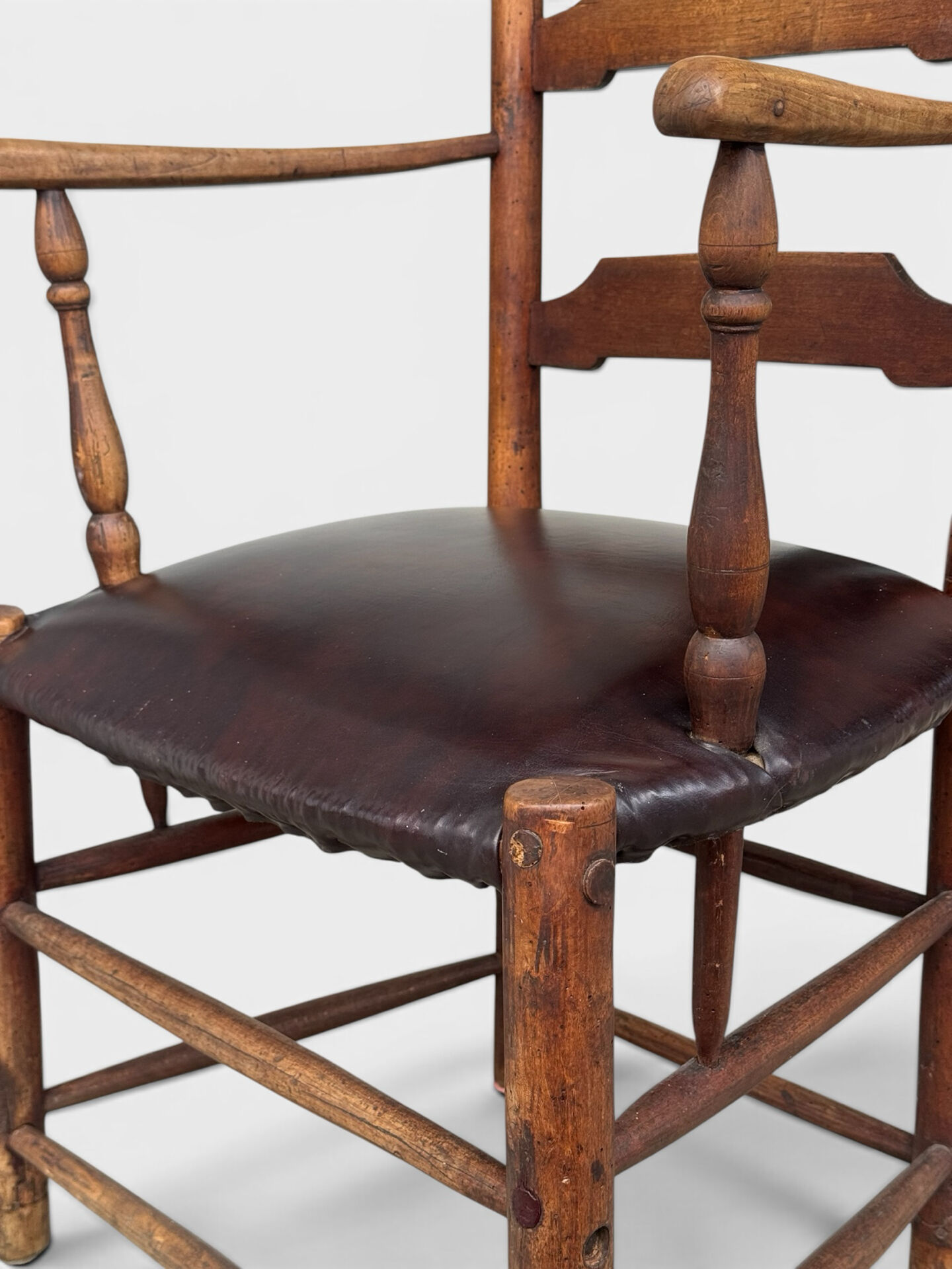 Antique rustic armchair in walnut and leather, 18th century.