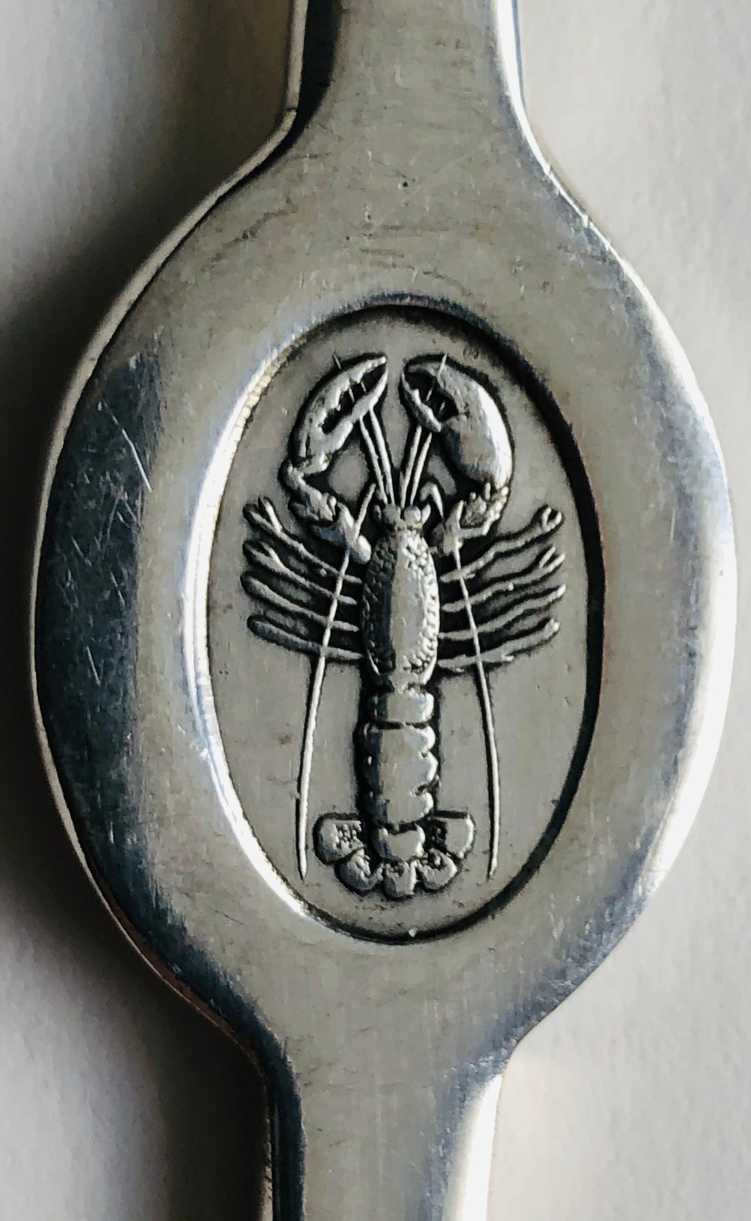 Ensemble de 4 curettes à homard en métal argenté, à décor de homard