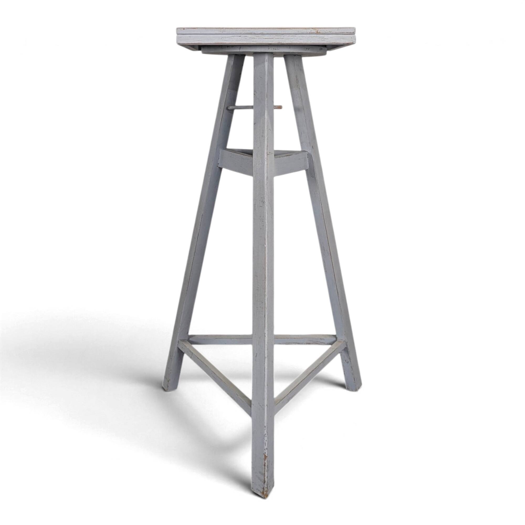 Tripod sculptor's stool in grey painted wood with a rotating top.