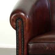 Vintage sheepskin club armchair with decorative nails and black piping