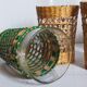 Four long drink glasses in vintage woven rattan cases
