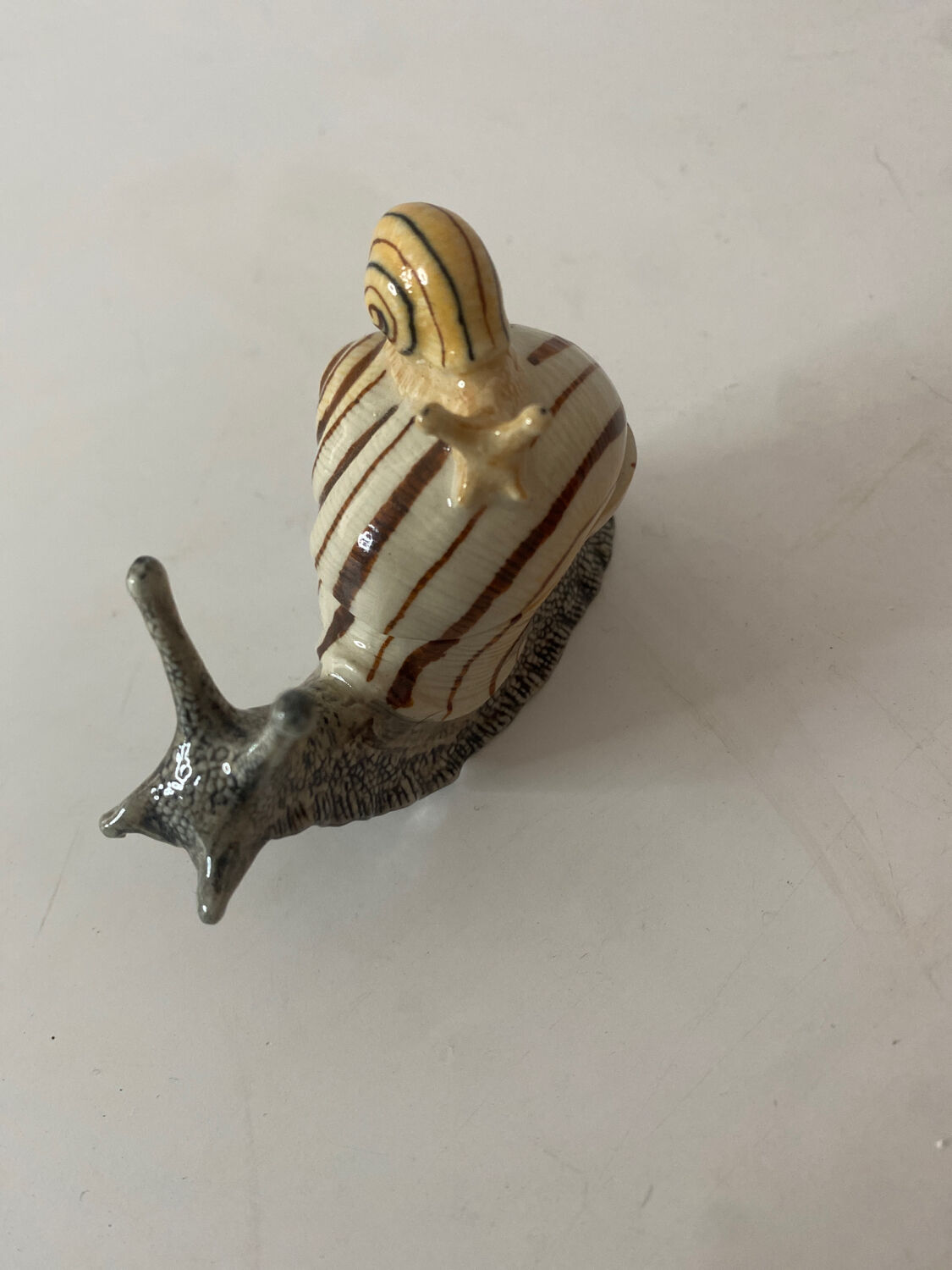 Porcelain figurine snail and its small