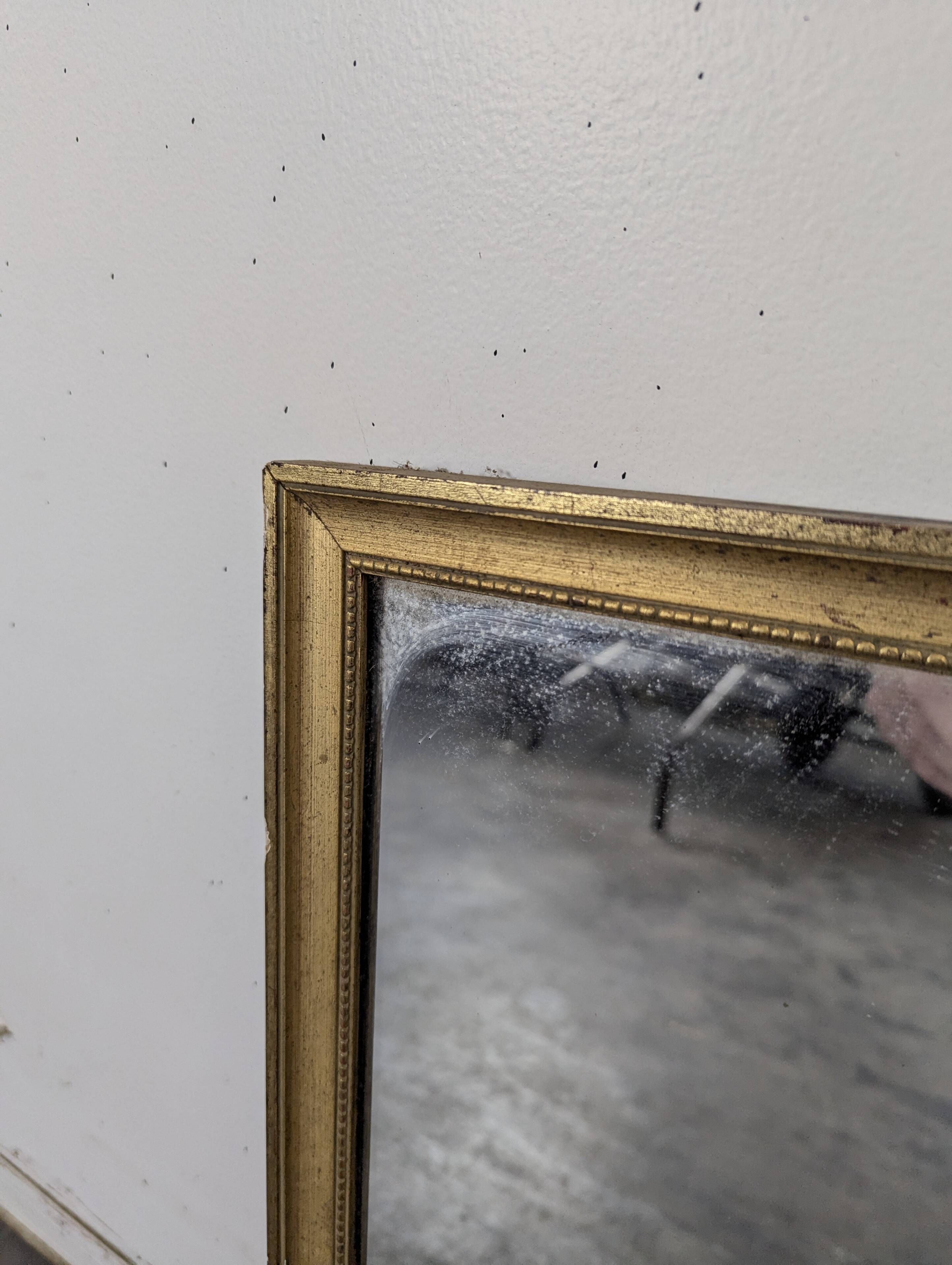Rectangular mirror with a gold wooden frame.
