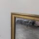 Rectangular mirror with a gold wooden frame.