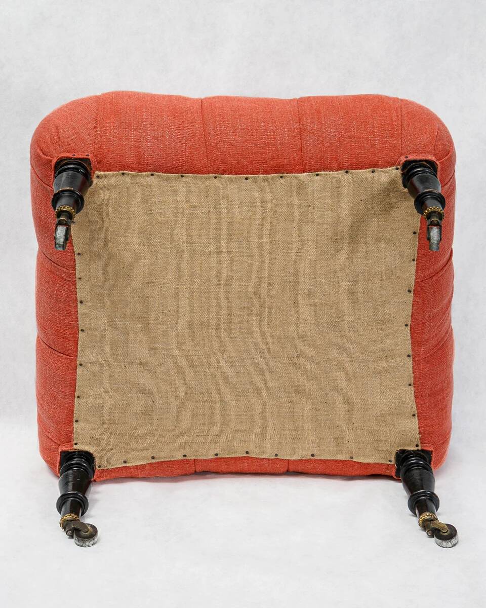 Napoleon III salon armchair in brick red linen with a tufted footrest.