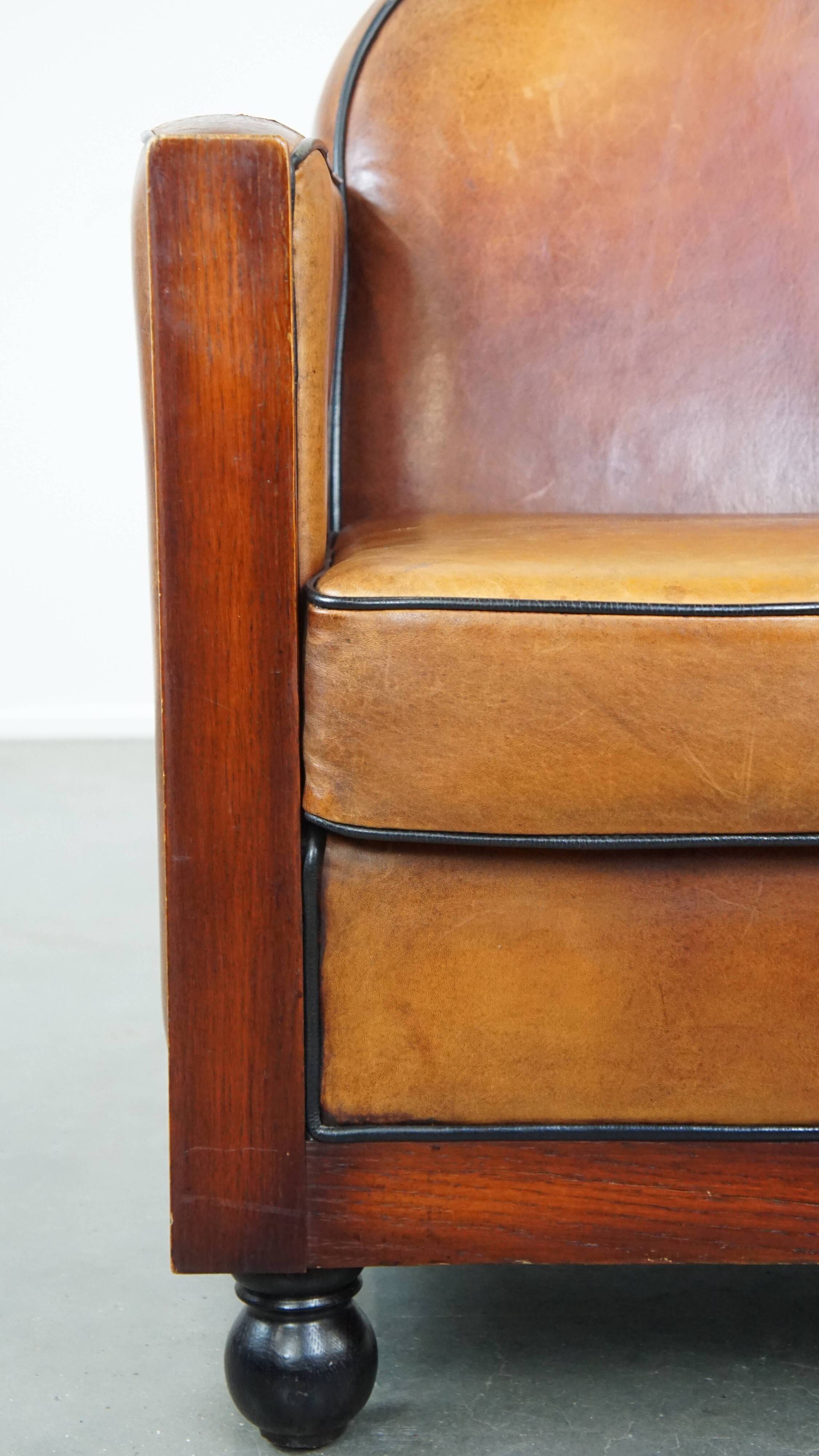 Sheep leather and wooden Art Deco design armchair with ball feet