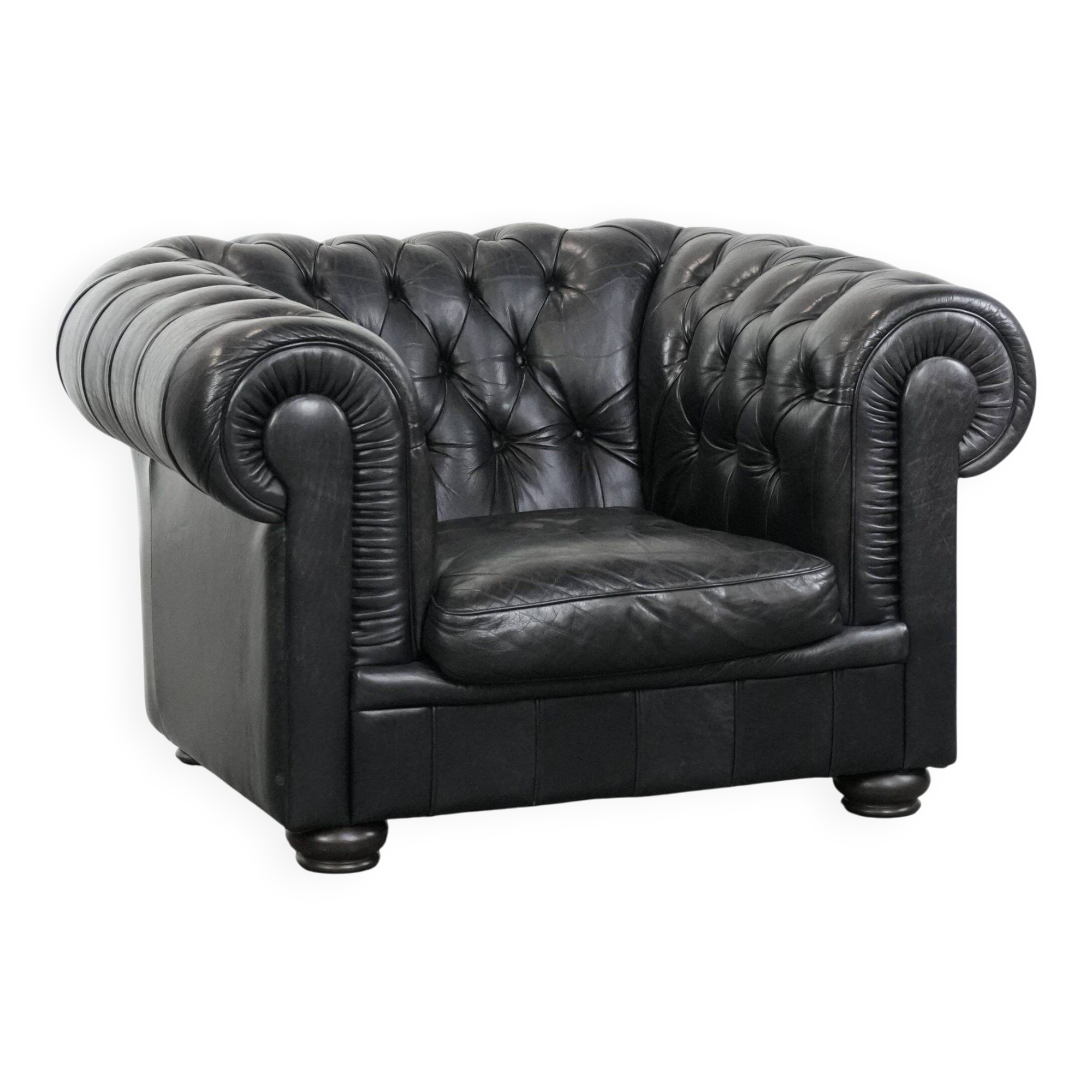 Comfortable black chesterfield armchair made of cowhide leather