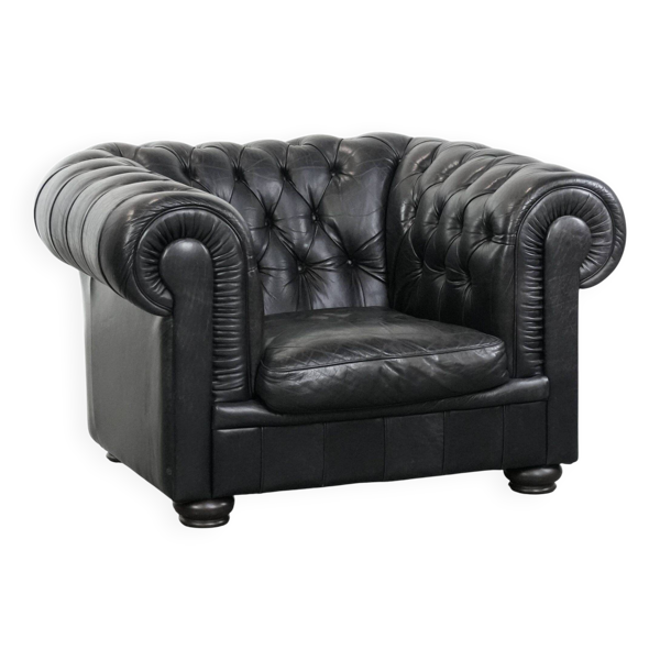 Fauteuil chesterfield noir confortable en cuir de vache.