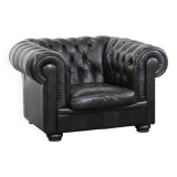 Comfortable black chesterfield armchair made of cowhide leather