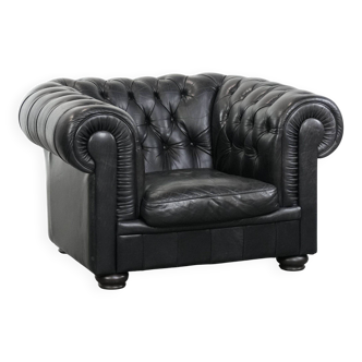 Comfortable black chesterfield armchair made of cowhide leather
