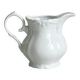 Old white porcelain milk jug, cream jug with relief.