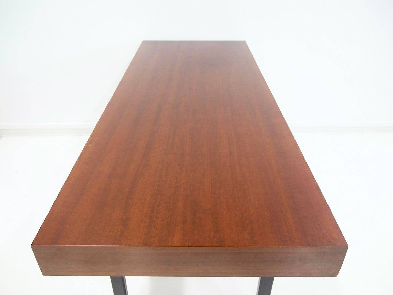 Wooden desk with drawers and black lacquered legs.
