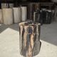 Black petrified wood side table with beige stripes and a semicircular shape.