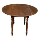 Round kitchen or dining table with extendable leaves in dark wood.