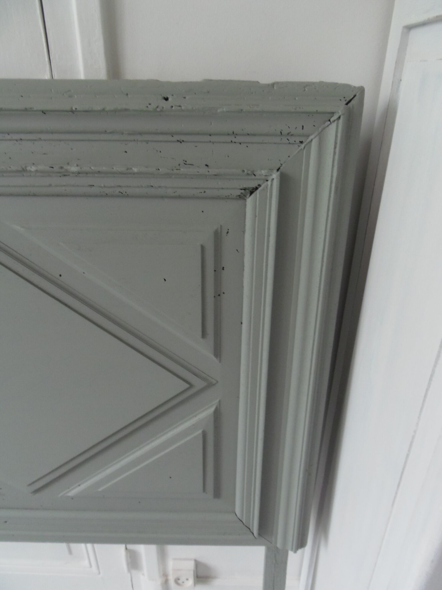 Headboard made with an old walnut door, re-enchanted in gray green waxed finish,