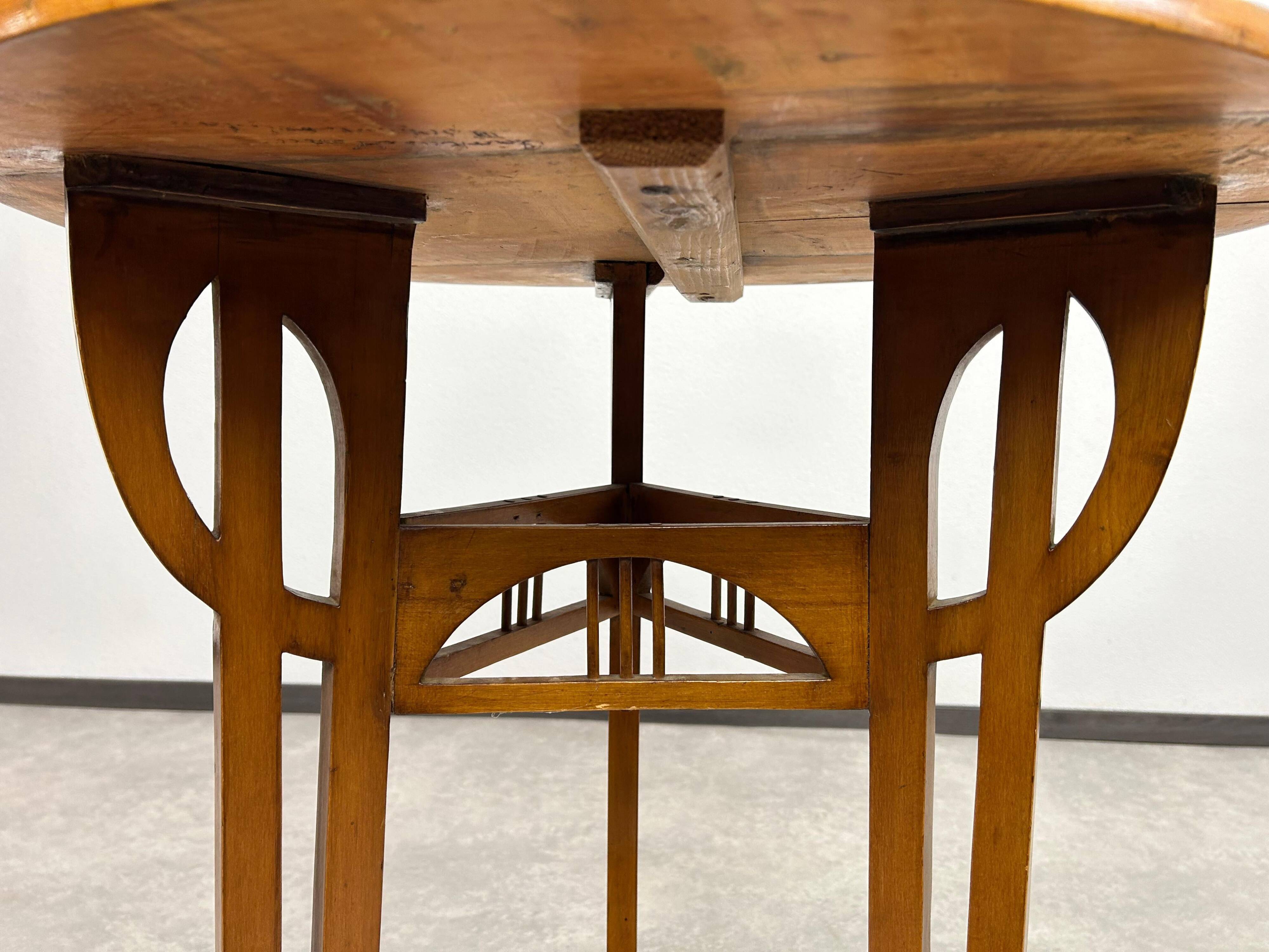 Round Art Nouveau coffee table with a sculpted top.