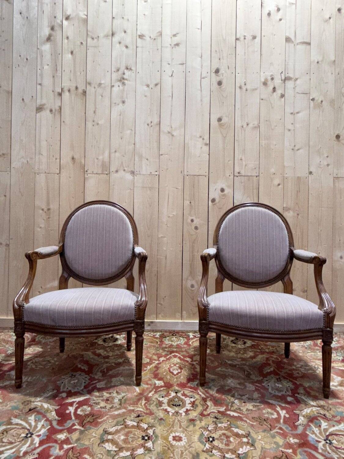 Pair of Louis XVI cabriolet armchairs with medallion backrest.