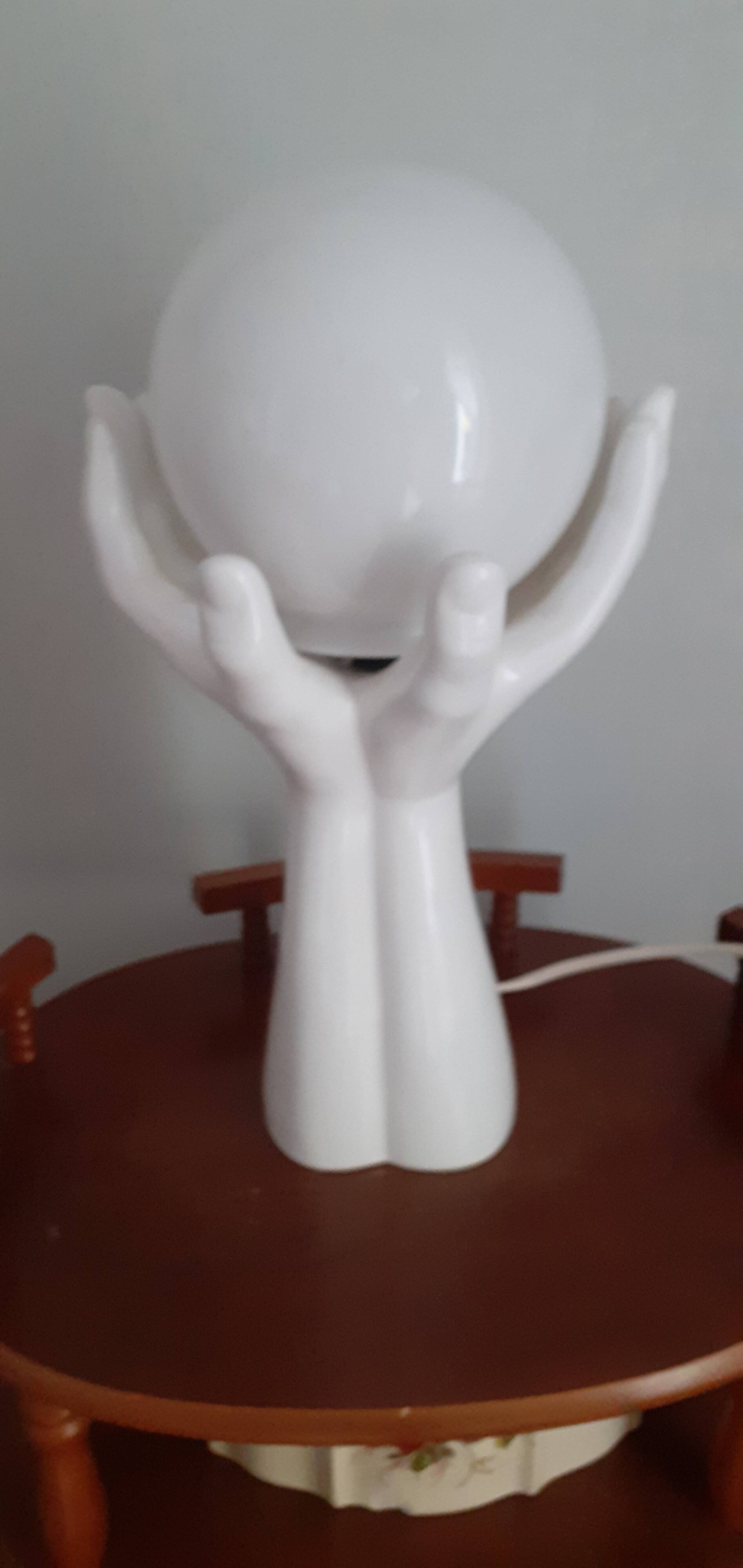 70s lamp two hands embrace an opaline globe