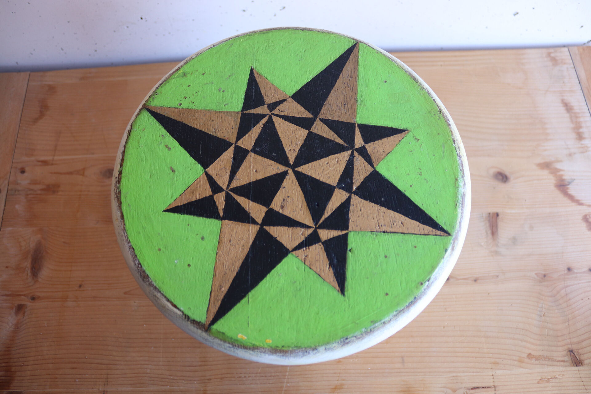 Small wooden stool painted with a star design.