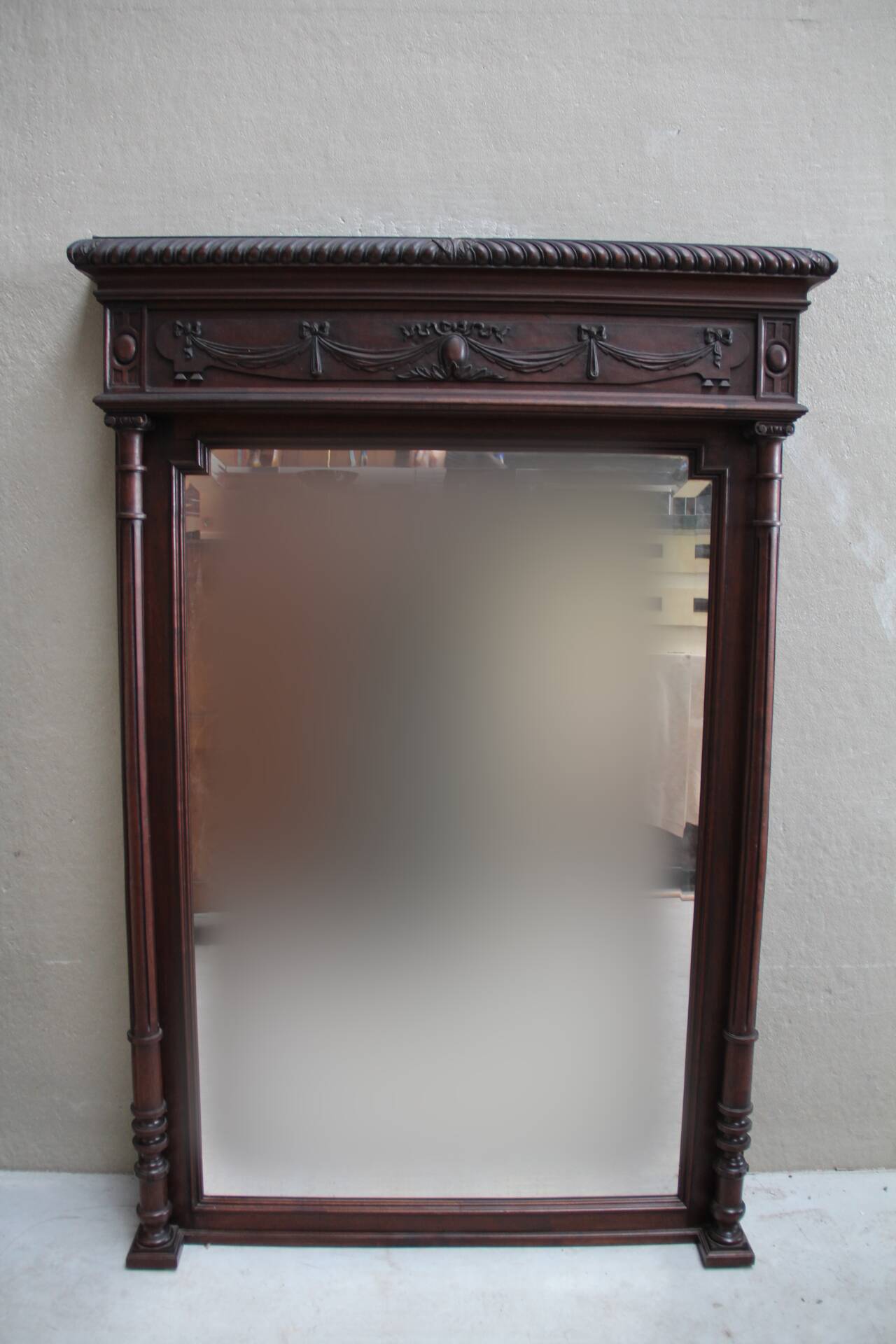 Imposing beveled mirror with wooden frame