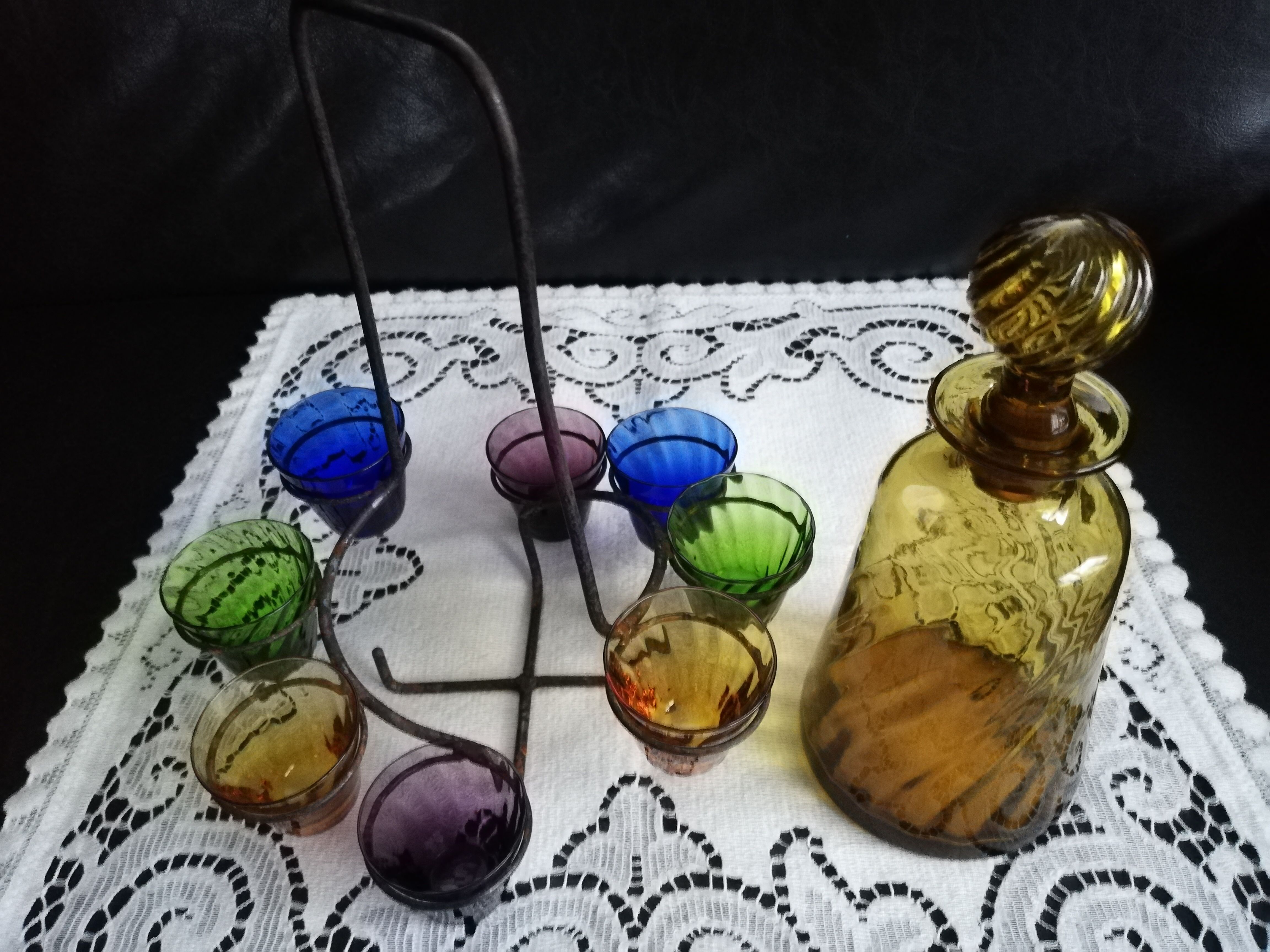Old Italian alcohol decanter and its colorful glasses