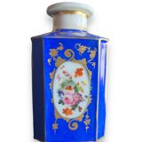 Perfume bottle in porcelain of old paris blue background
