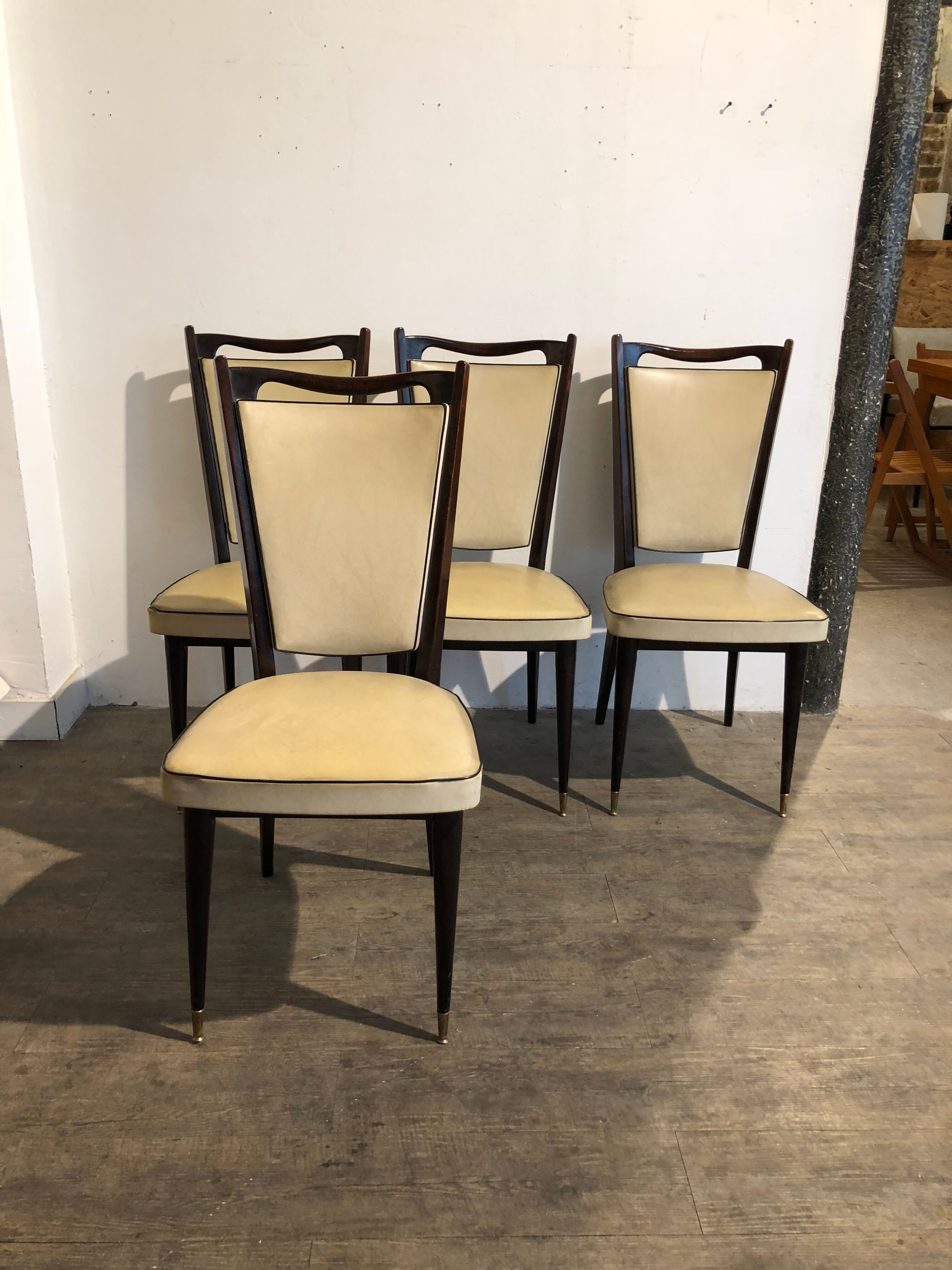 Four white leatherette chairs