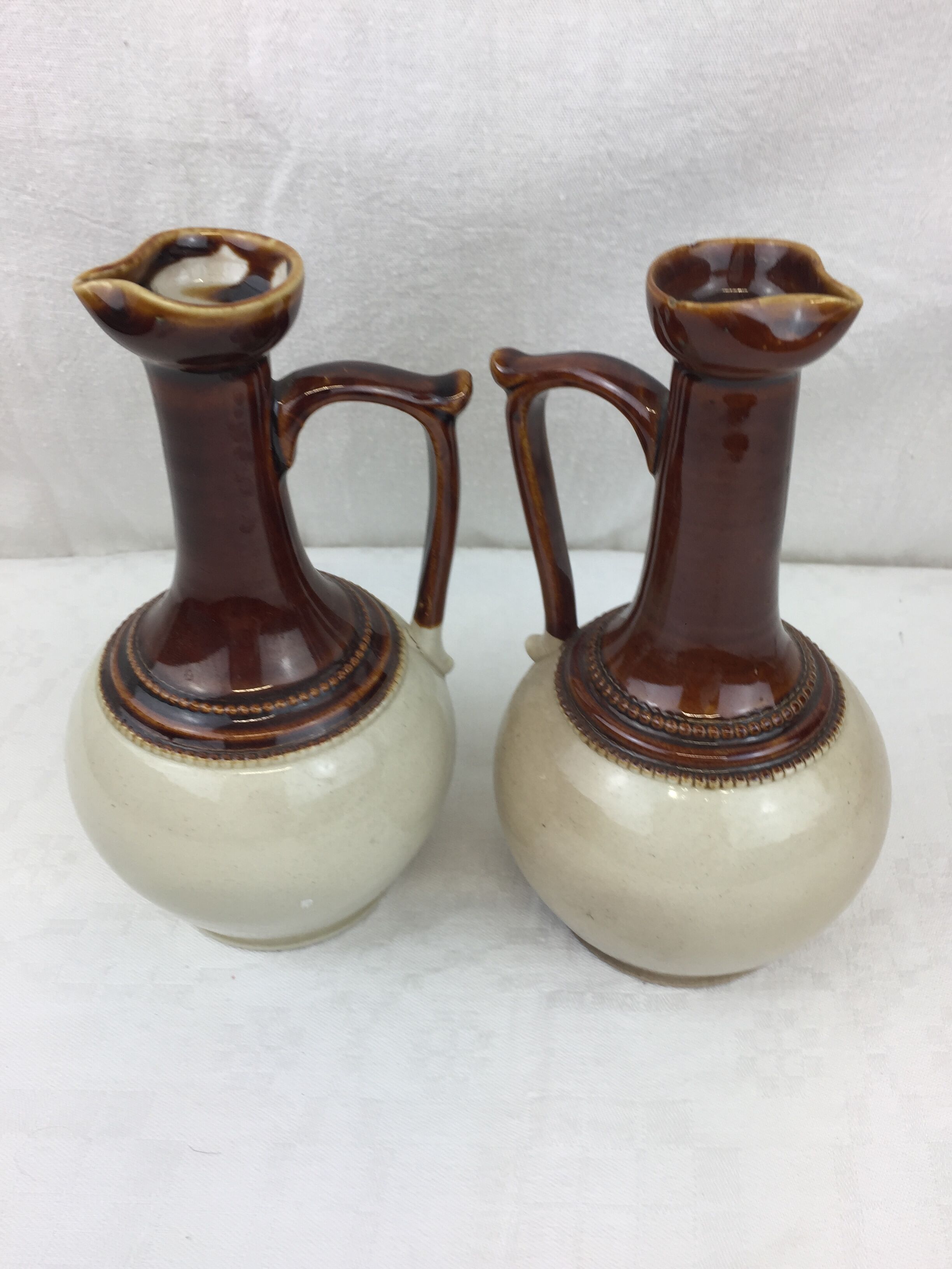 Antique handmade pitchers in beige and brown enamelled terracotta