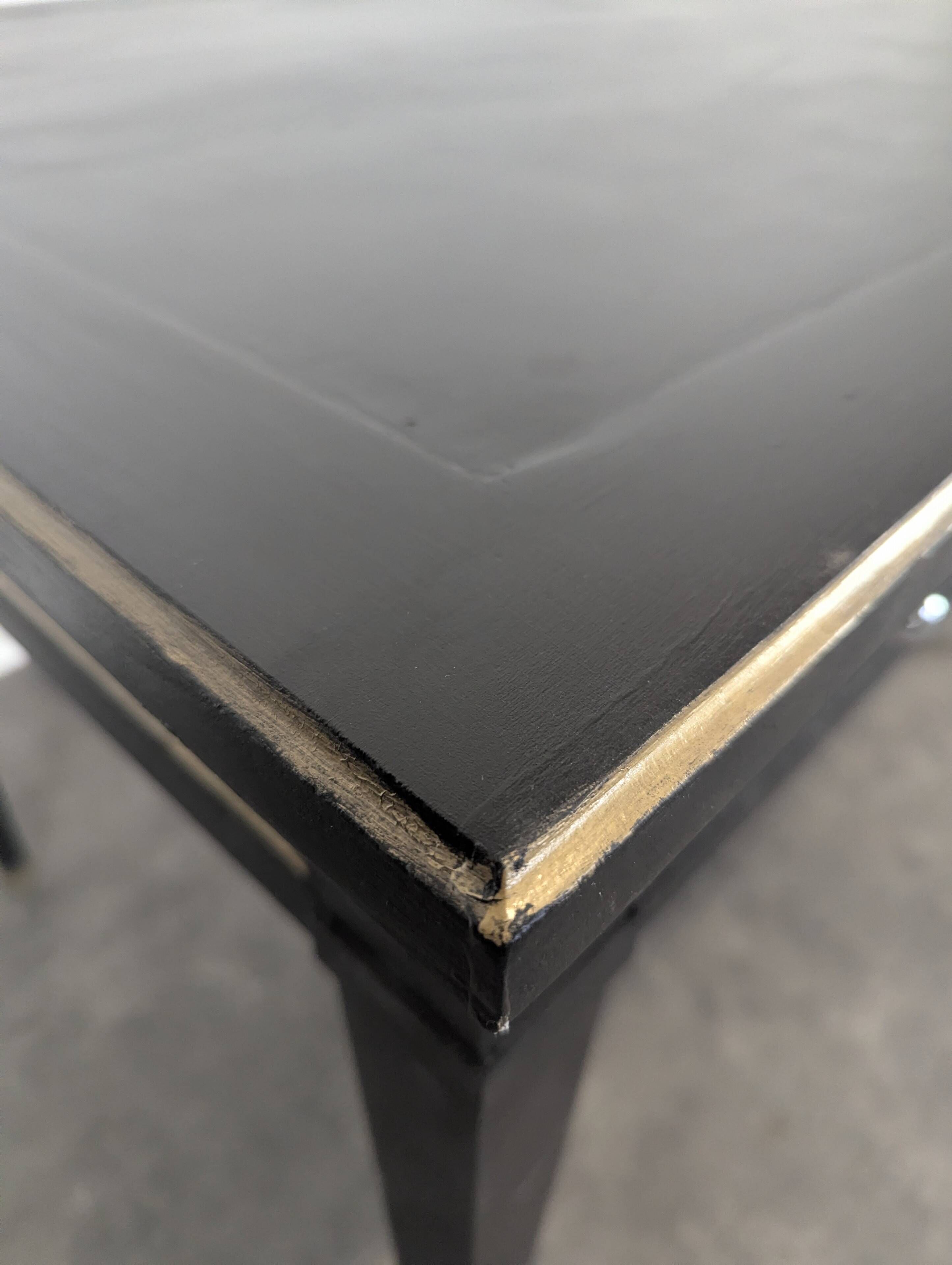Large flat desk in Louis XVI style, black lacquered with gold highlights.