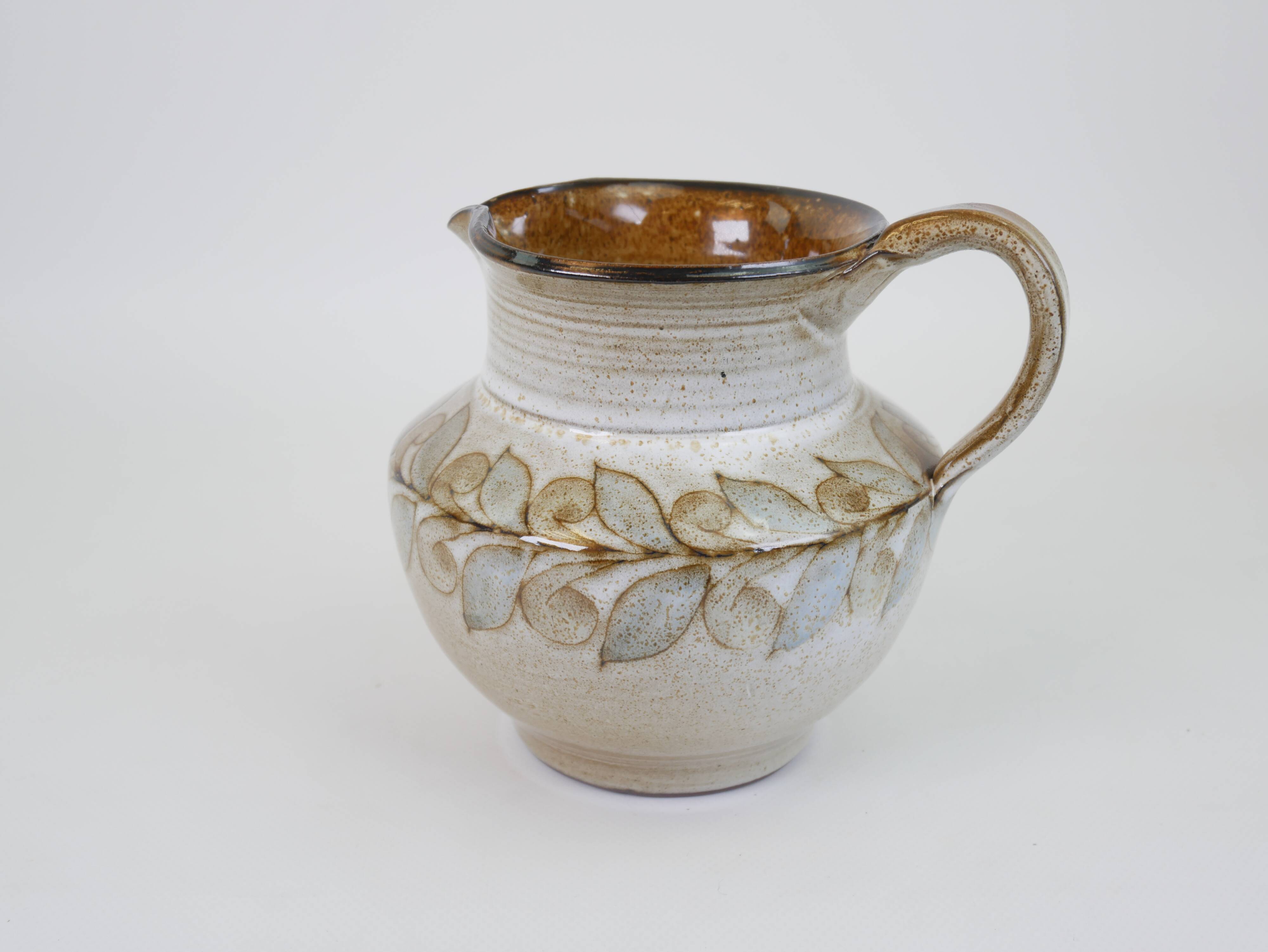 Glazed ceramic jug with plant decoration