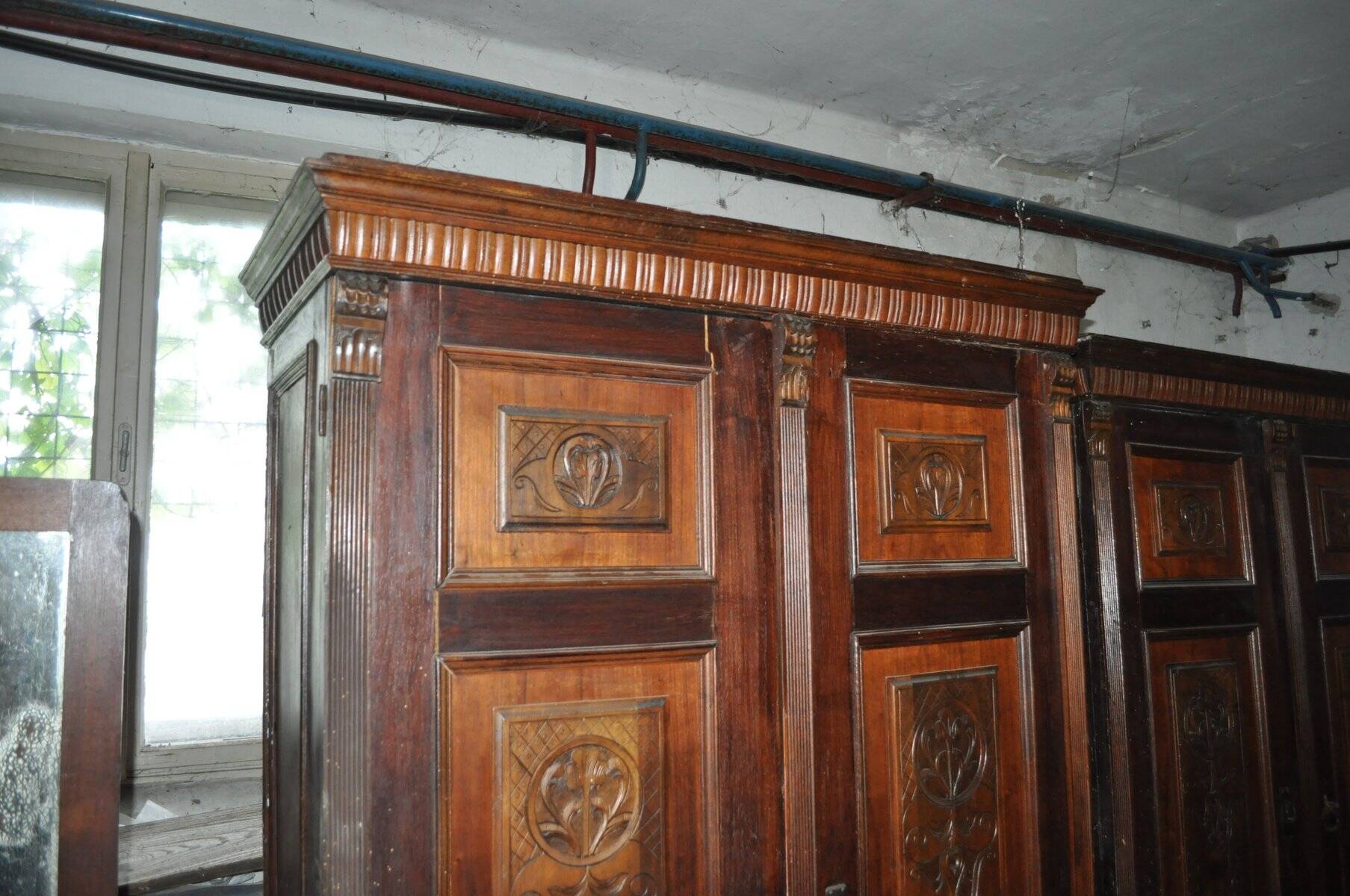 Hungarian wardrobe in carved brown wood from the late 19th century, with 2 doors and a lower drawer.
