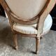 Medallion back chair in moulded wood and beige fabric.
