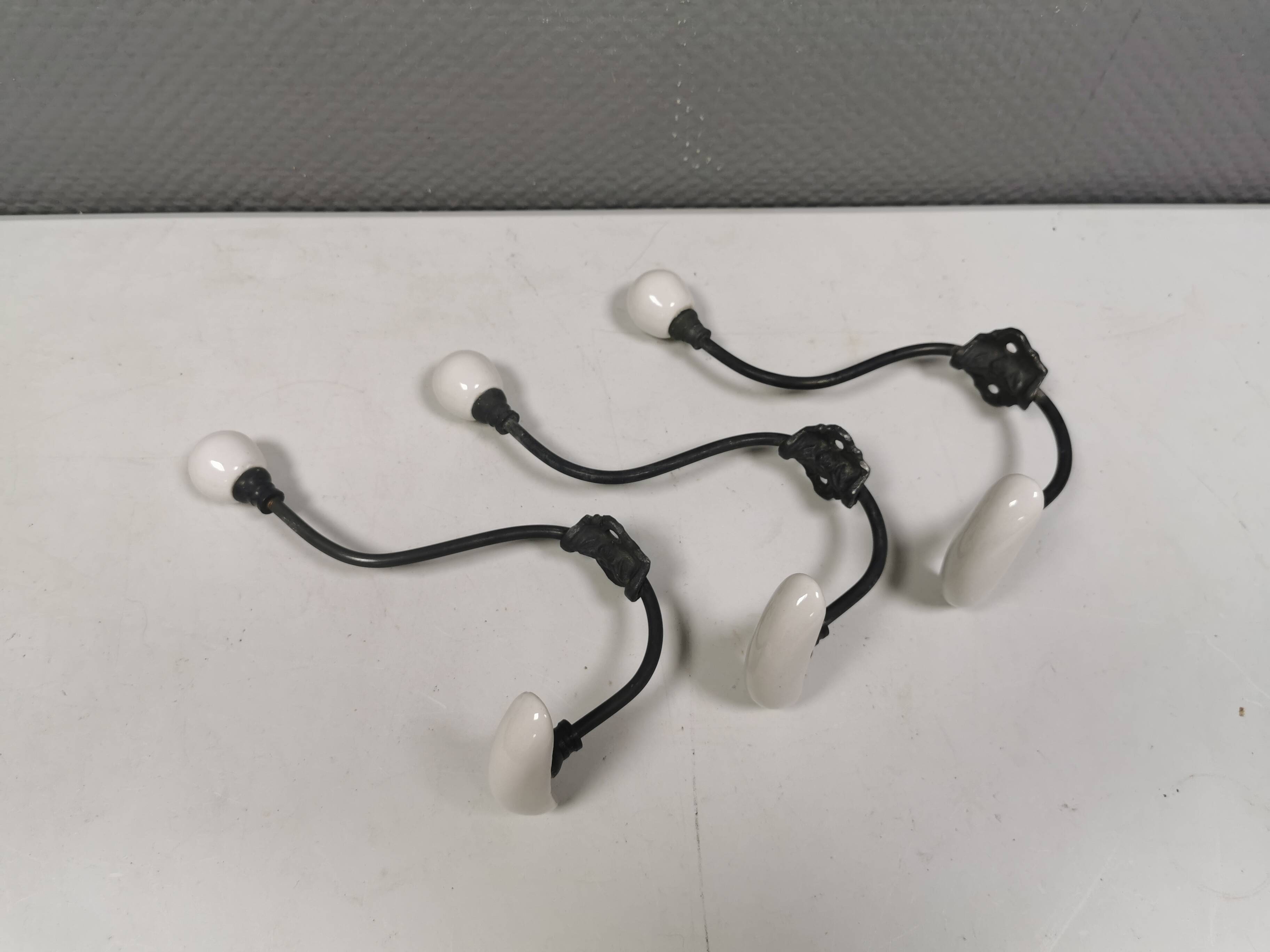 Coat hooks made of galvanized brass and raw white porcelain