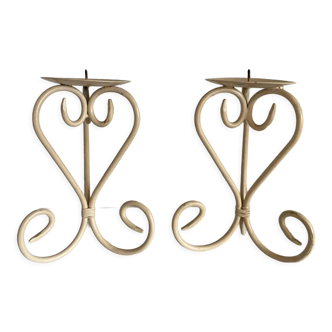 Two beige iron candle holders in a heart shape
