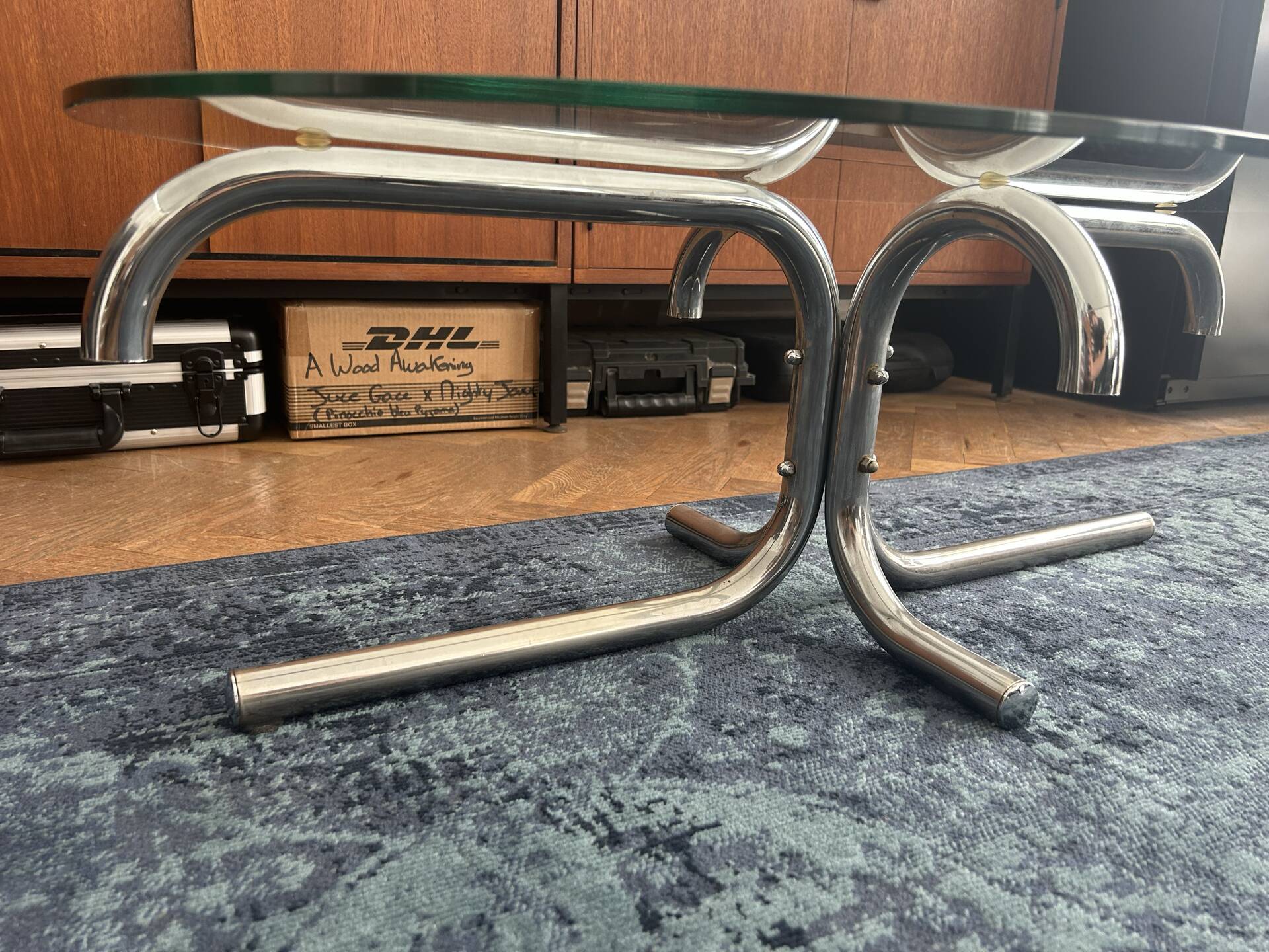 Oval glass coffee table with chrome legs, vintage 70s design.