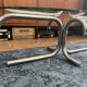 Oval glass coffee table with chrome legs, vintage 70s design.