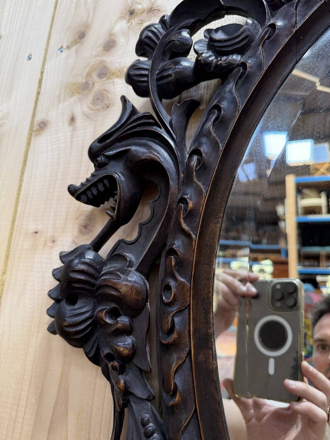 Oval mirror in carved wood with dragon heads.