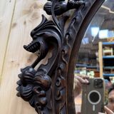 Oval mirror in carved wood with dragon heads.