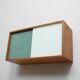 A vintage mid-century wall hung oak cabinet, green & white glass doors