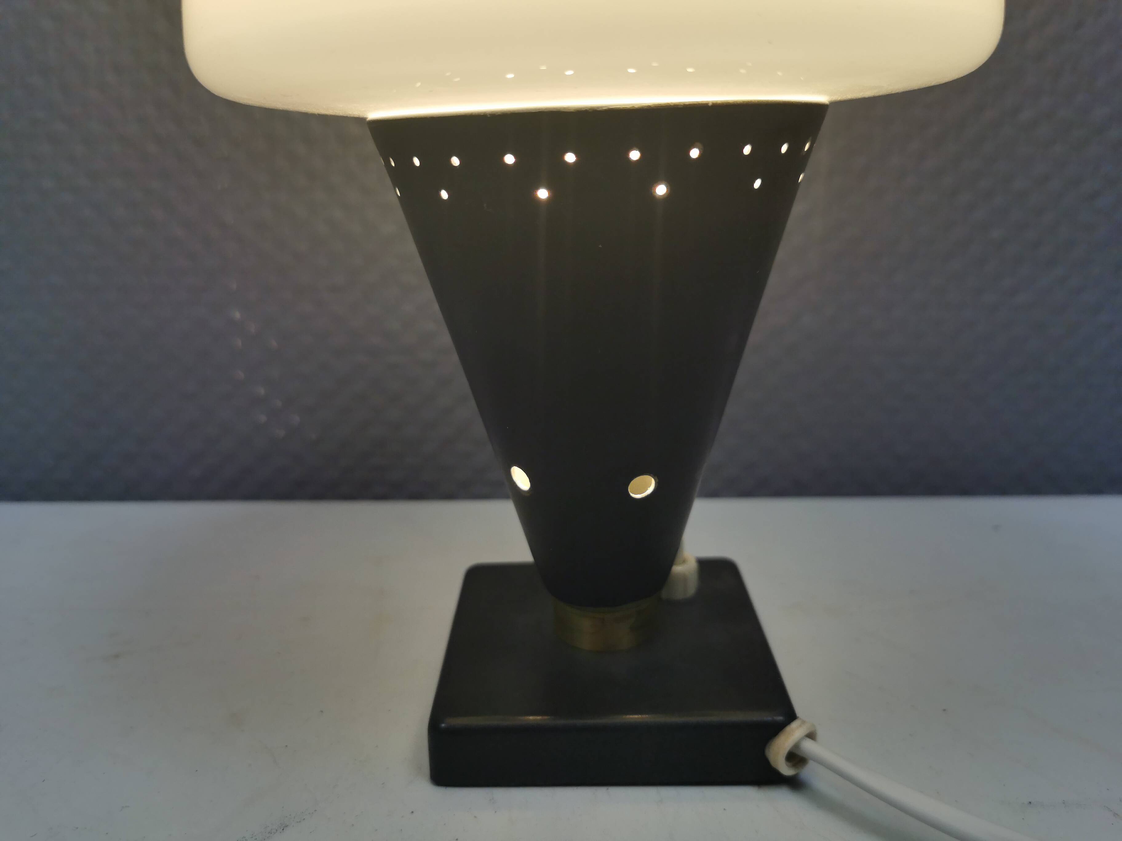 Small stylish table lamp with perforations and milky white opal glass shade