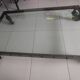 Industrial coffee table in solid metal with a glass top.